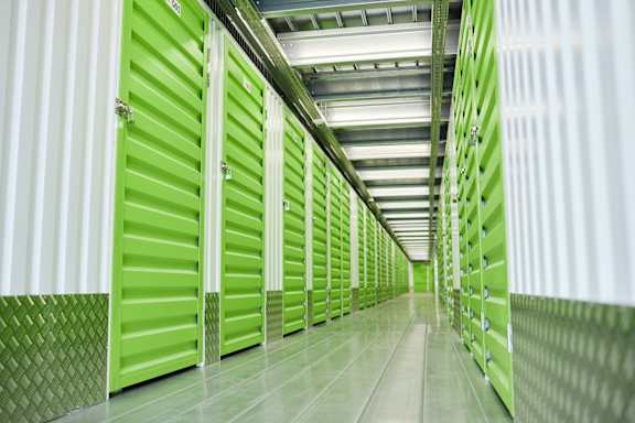 A long corridor of green storage units in a data center.