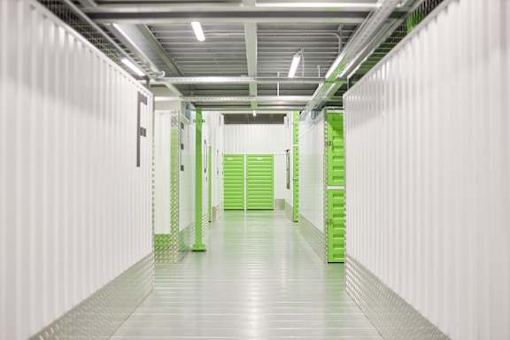 A long hallway with green shelves on the right.