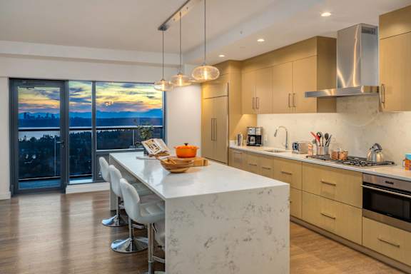 a kitchen with a large island with a white marble counter top and a large window at Two Lincoln Tower Apartments, Bellevue, WA, 98004