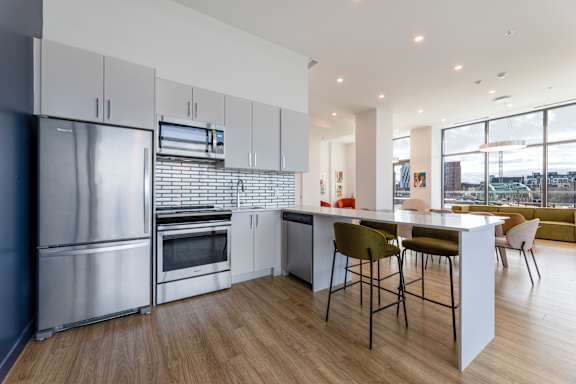 A modern kitchen with a large island and stainless steel appliances.