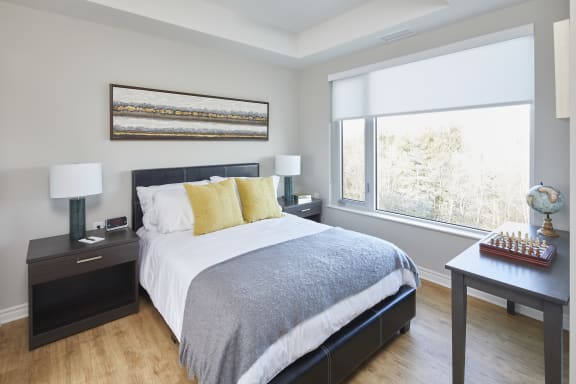 A bedroom with a large bed and two windows
