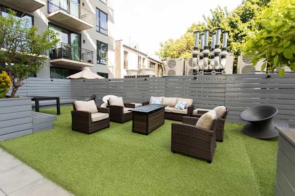 Outdoor courtyard with seating area and artificial turf at 1134 Fulton Street Apartments, New York, 11216