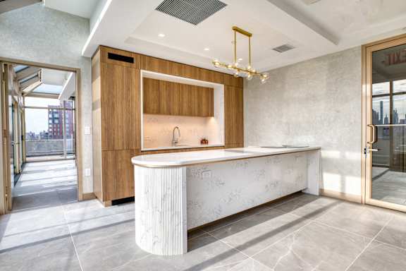 A modern bathroom with a large marble countertop and wooden cabinets.at 301E94, New York New York