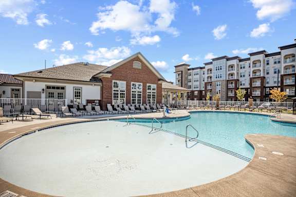 A large outdoor swimming pool with a diving board and lounge chairs at Ellis Station, Durham, North Carolina