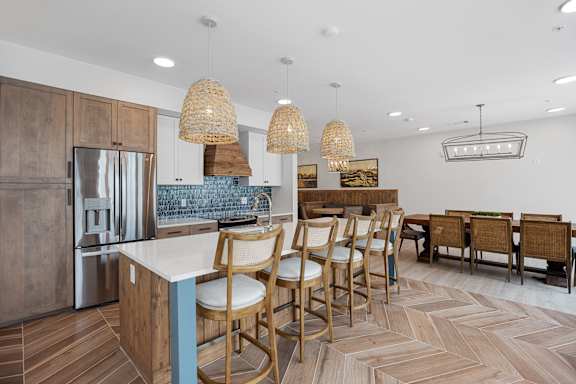 a kitchen with a large island and a dining room with chairs at Oak Grove at Blake Farm, NC, 28411