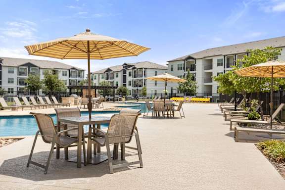 A poolside area with chairs and umbrellas.