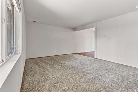 a bedroom with white walls and a carpeted floor