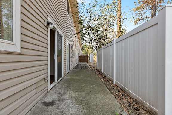an alleyway between two buildings with trees in the background