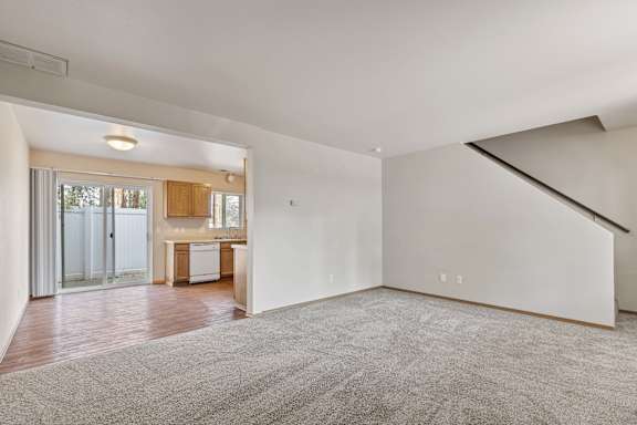 a living room with a staircase leading up to a kitchen