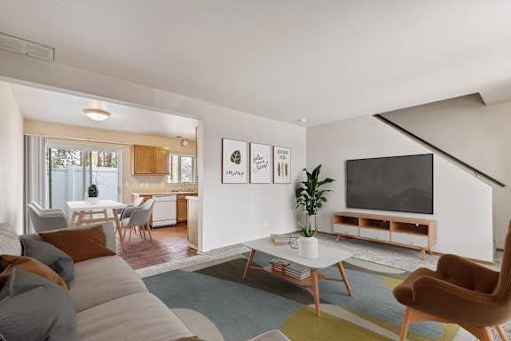 a living room with a couch a coffee table and a tv on the wall