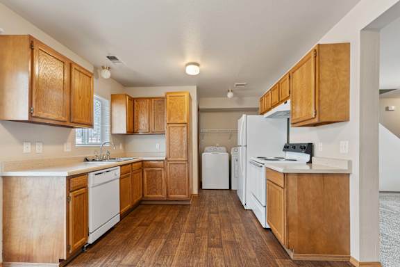 a kitchen with white appliances and wooden cabinets