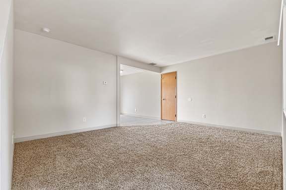 a bedroom with white walls and carpet