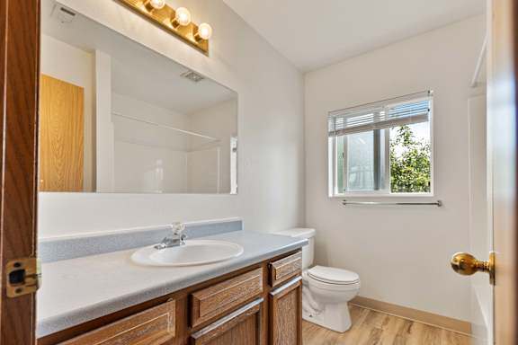 a bathroom with a toilet sink and mirror