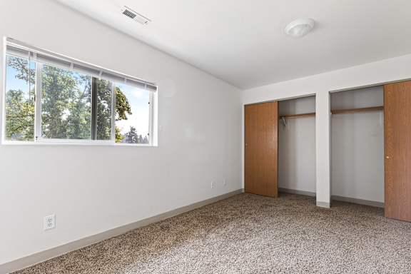 a bedroom with white walls and carpet