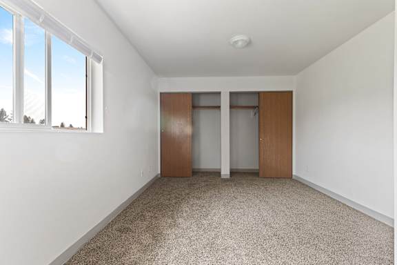 a bedroom with white walls and carpet