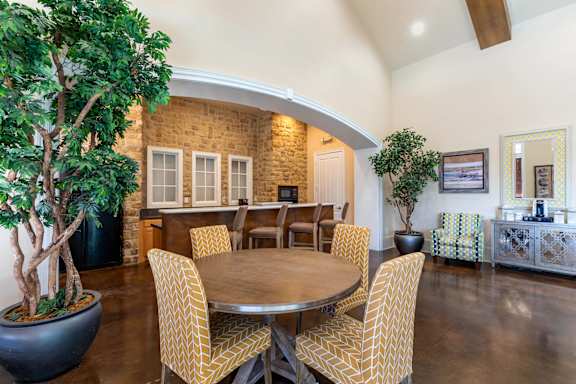 A dining room with a round table surrounded by chairs.