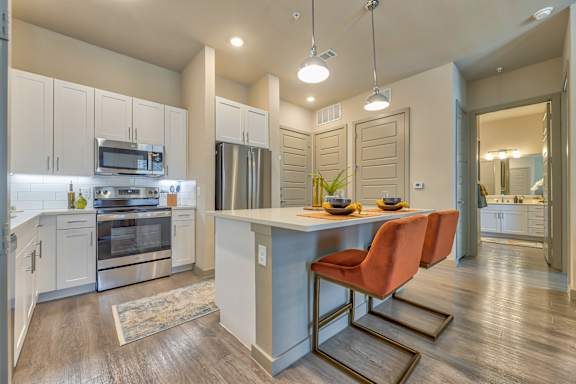A kitchen with a table and chairs in the middle of it.