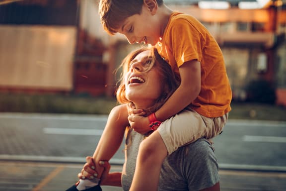 a young boy is sitting on the shoulders of a woman
