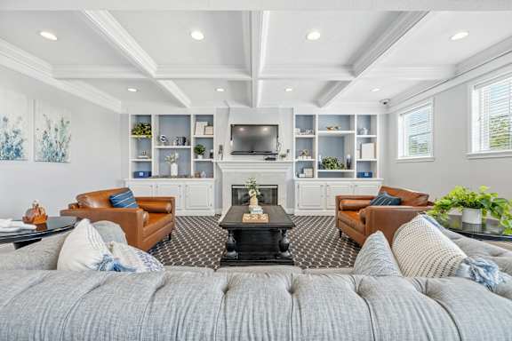 A bedroom with a large bed, a nightstand, and a window with white curtains.