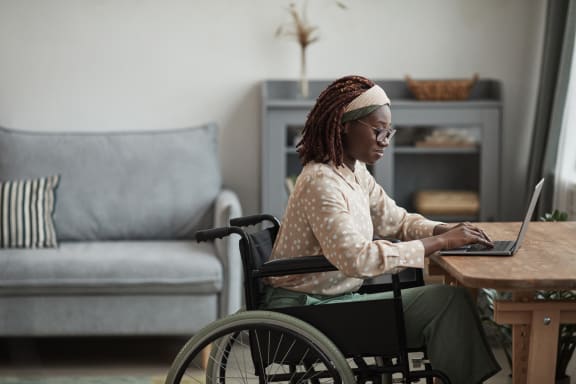 a woman in a wheelchair working on a laptop computer at Union 346, Somerville, Massachusetts, 02143