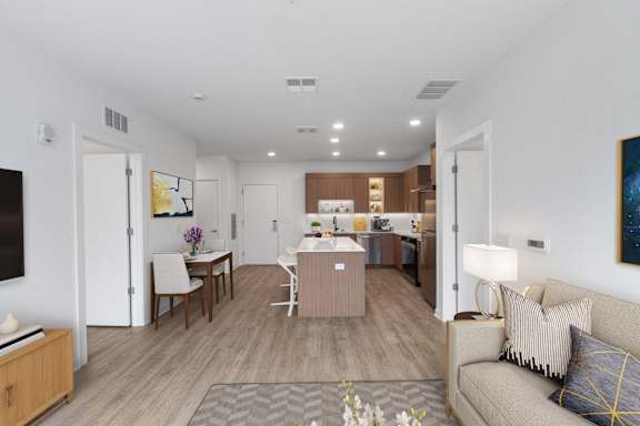 A modern living room with a dining area and kitchen in the background.