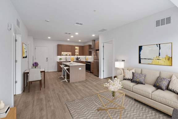 A modern living room with a dining area and kitchen in the background.