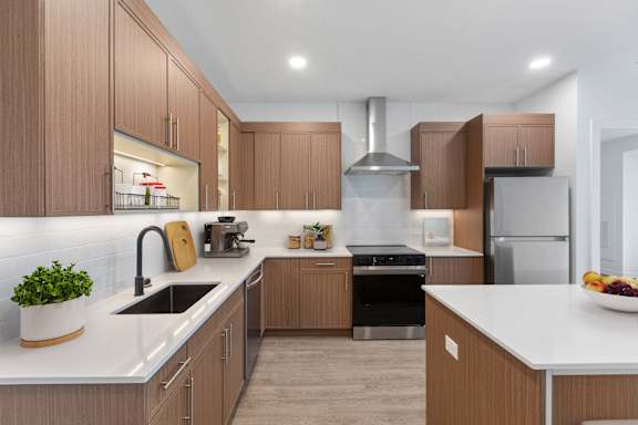 A modern kitchen with wooden cabinets and stainless steel appliances.