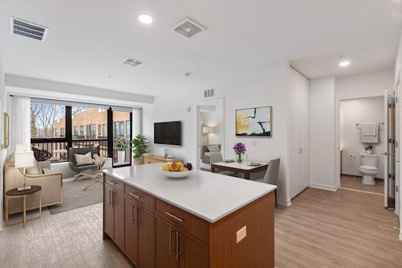 A modern kitchen with a white countertop and wooden cabinets.