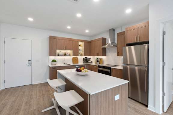 A modern kitchen with a white countertop and stainless steel appliances.