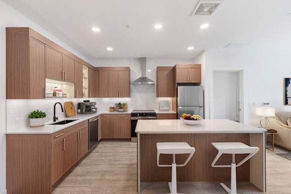 A modern kitchen with wooden cabinets and white countertops.