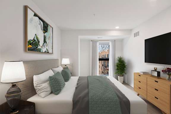 A bedroom with a large bed, a nightstand with a lamp, a plant, and a painting on the wall.