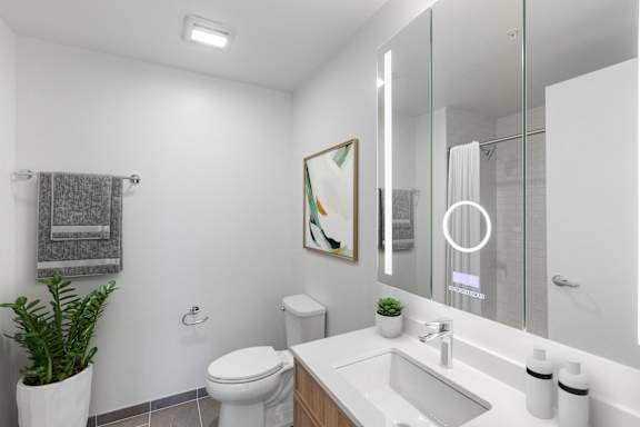 A white toilet sits next to a sink in a modern bathroom.