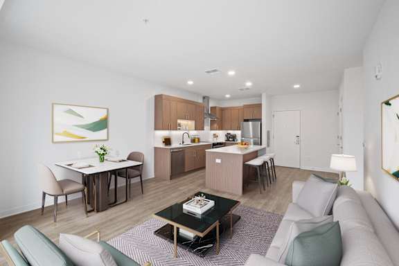 A modern living room with a dining area and kitchen in the background.