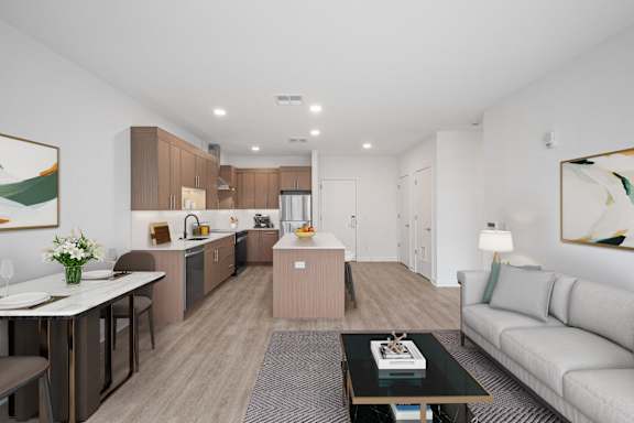 A modern living room with a dining area and kitchen in the background.