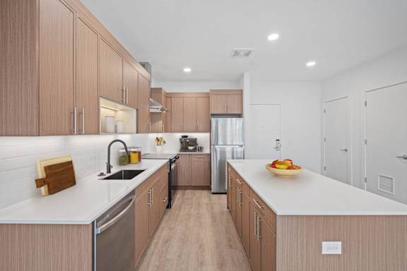 A modern kitchen with wooden cabinets and stainless steel appliances.
