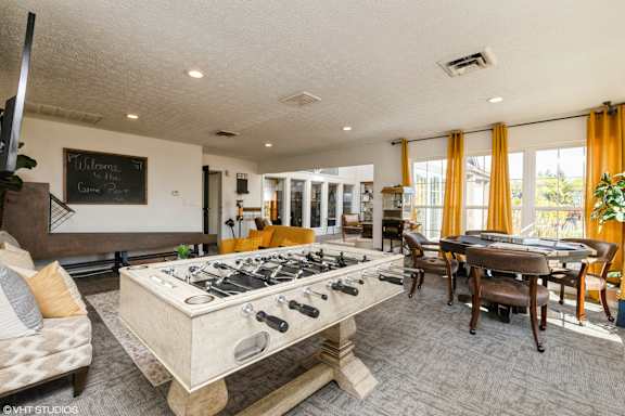 A foosball table is in the middle of a living room. at Island Club Apartments, Columbus, OH, 43235