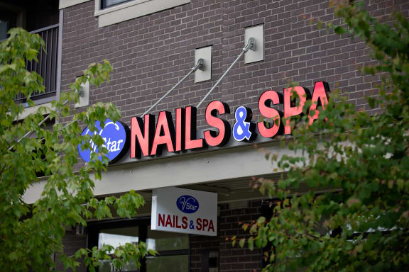 a sign for nails & spa on the side of a building