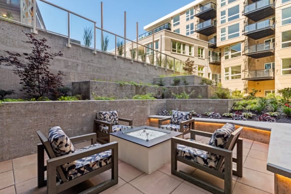 an outdoor patio with a firepit and lounge chairs