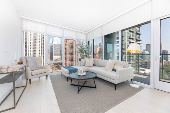 a living area with a couch coffee table and large windows