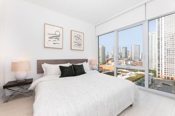 a bedroom with a large bed next to a window