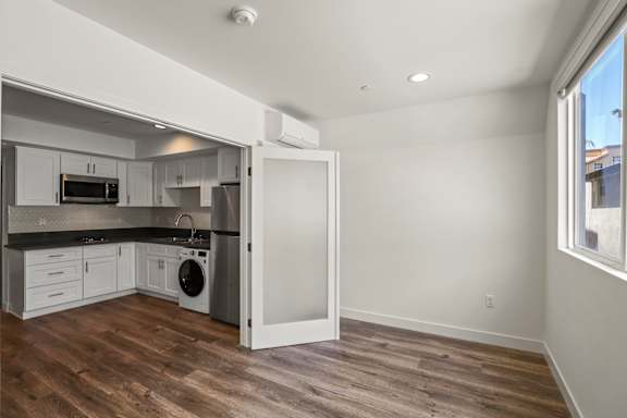 Open-Concept Kitchen Area with Stainless Steel Appliances and Washer/Dryer Combo