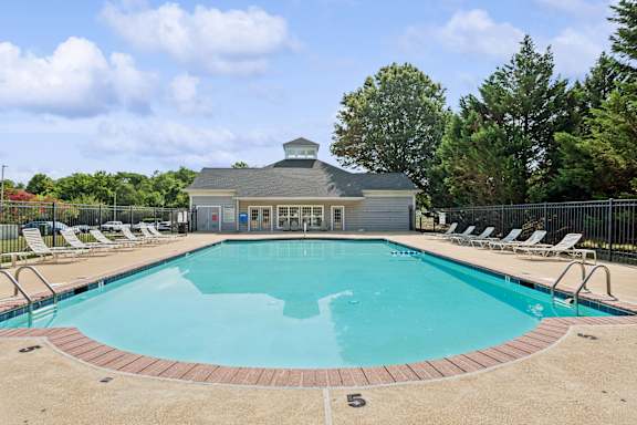 A large outdoor swimming pool with a building in the background.