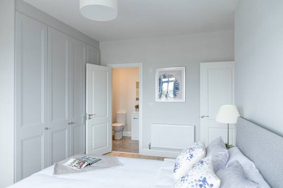 a bedroom with a bed and a door to a bathroom