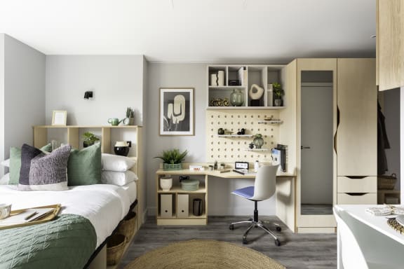 a small bedroom with a bed and a desk with a chair
