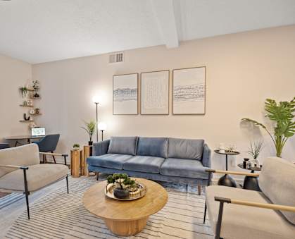 A living room with a grey sofa, a wooden coffee table, and a blue chair.