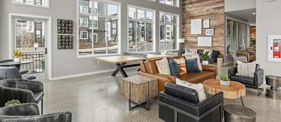 an open living room with large windows and a wooden ceiling