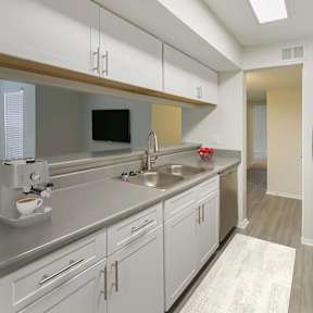 A modern kitchen with a black refrigerator and stove top.