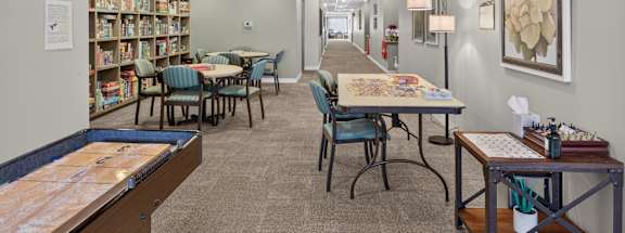 A library with tables, chairs, and bookshelves.