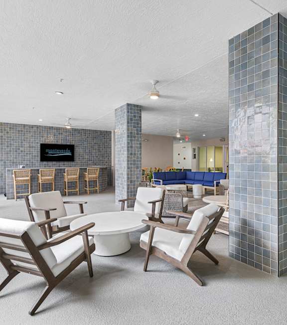 A modern living room with a white couch and a blue tile column.