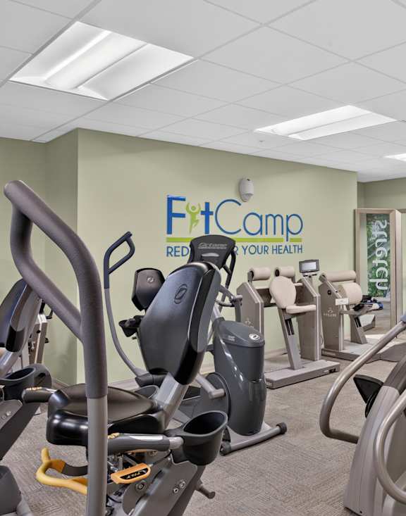 A gym with a variety of equipment including treadmills, stationary bikes, and weight machines.